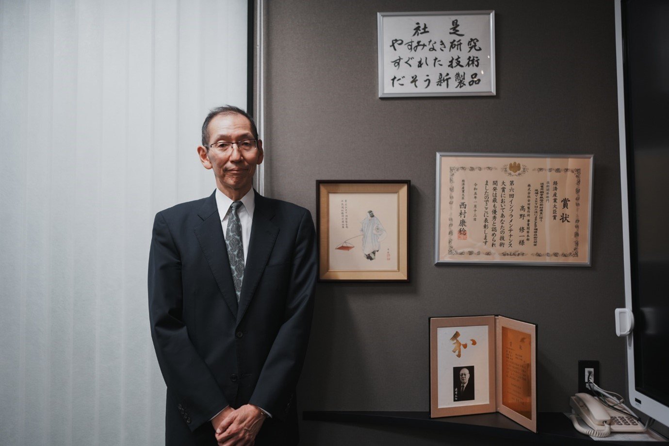 社是「やすみなき研究・すぐれた技術・だそう新製品」を背景に